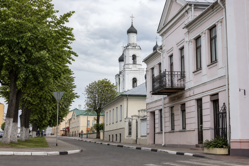A quiet street in Orsha, Belarus, with leafy trees and traditional city buildings