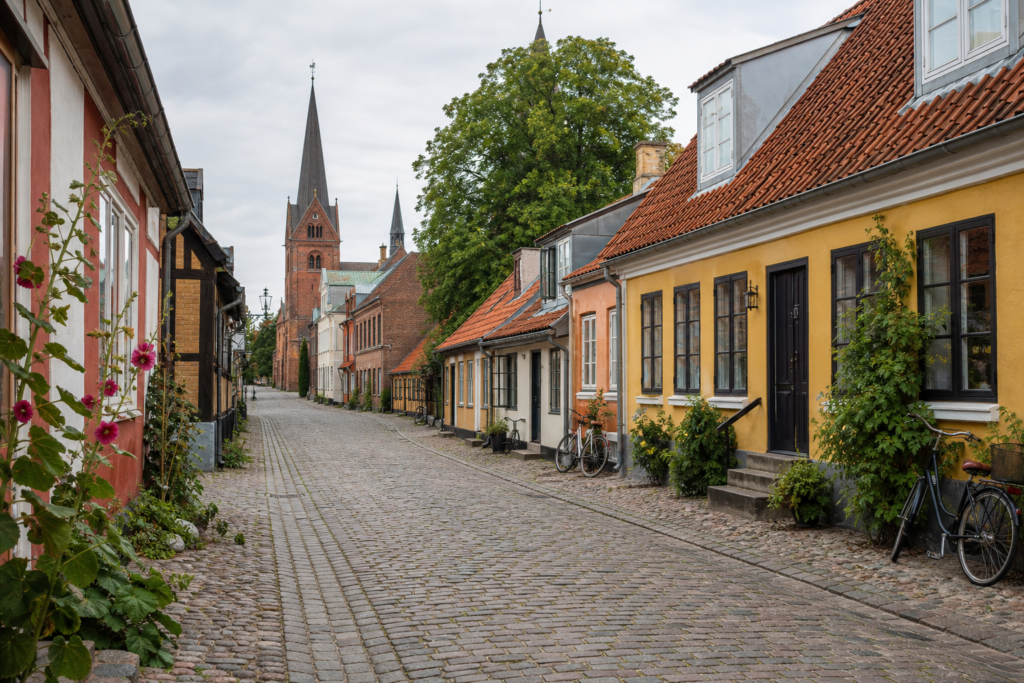 Historic street with colorful houses and bicycles in Odense, Denmark